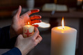 Jemand zündet eine Kerze an der Osterkerze in einer Kirche an.