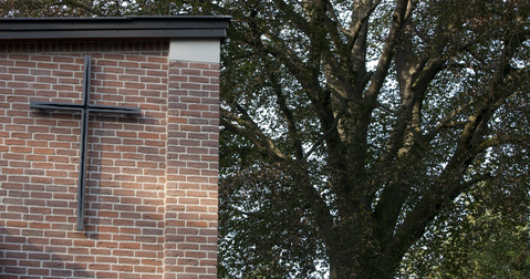 Kreuz an einem Gebäude auf dem Friedhofsgelände