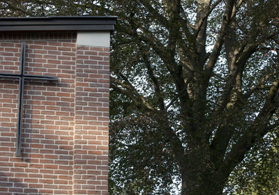 Kreuz an einem Gebäude auf dem Friedhofsgelände