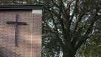 Kreuz an einem Gebäude auf dem Friedhofsgelände