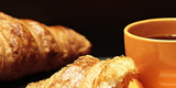 Das Foto zeigt Croissants und eine Tasse Kaffee