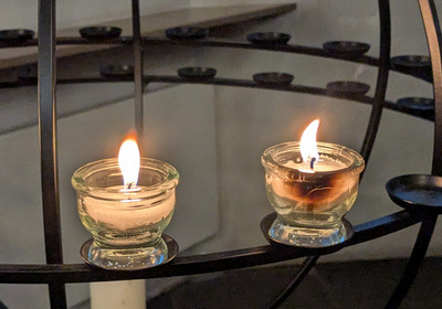 Zwei brennende Teelichter auf einem metallenen Ständer
