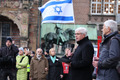 Das Foto zeigt eine Solidaritäts-Demonstration für Israel auf dem Bremer Marktplatz mit Bernd Kuschnerus. Im Hintergrund eine israelische Flagge.