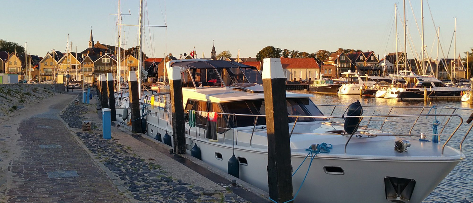 Ein Boot liegt an einem Anleger und wird vom Sonnenuntergang beleuchtet.