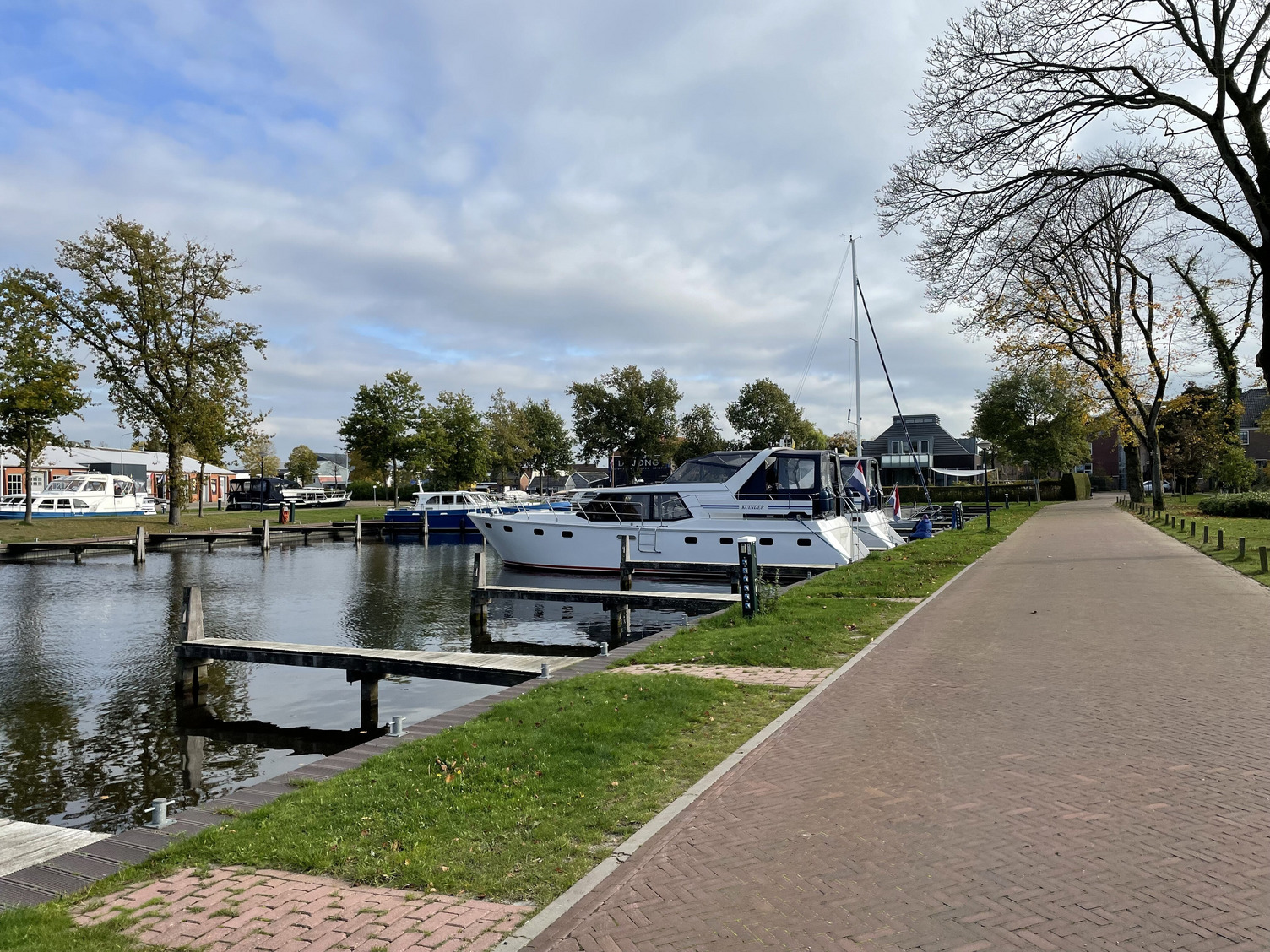 Zwei Boote liegen in einem Hafen nebeneinander. Der Hafen ist ansonsten leer und die Sonne scheint.