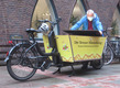 Der Imker Heiner Lenz verstaut seine Werkzeuge in seinem Lastenfahrrad mit Bienenlogo und dem Schriftzug "Der Bremer Bienenkönig".