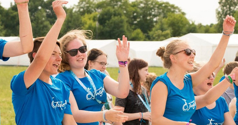 Eine Gruppe der Evangelischen Jugend tanzt bei einem Zeltlager.