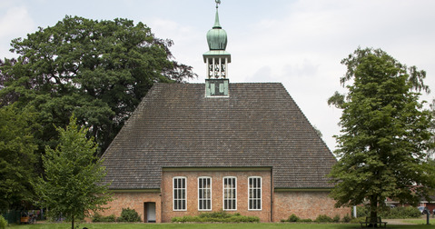 Kirchgebäude mit Turm in der Mitte des Daches.