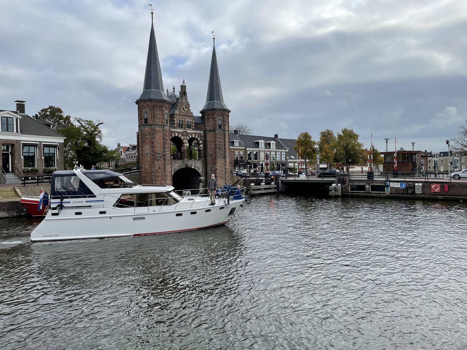 Ein Boot fährt an einem alten Wassertor vorbei.