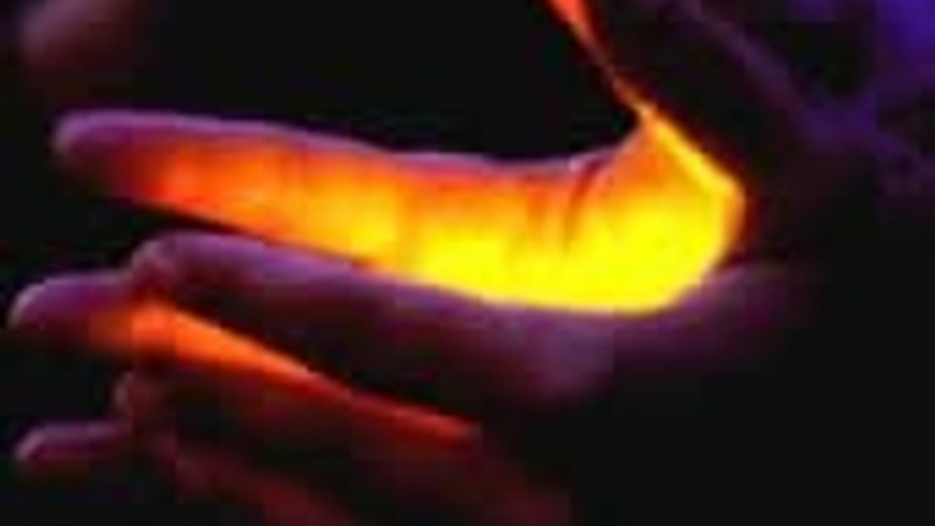 Eine Hand hält eine andere Hand, wobei zwischen ihnen ein warmes, gelb-orangefarbenes Licht strahlt. Der Hintergrund ist dunkel und verstärkt den Kontrast des Lichtes. Die Geste vermittelt ein Gefühl von Intimität und Verbindung.
