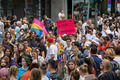 Viele Menschen demostrieren auf dem CSD in Frankfurt am Main, 16. Juli 2022. Eine Person hält ein neon-pinkes Plakat mit dem Schriftzug "Queer-Denken statt Querdenken". Eine Person daneben schwenkt eine Pan-Flagge (Flagge für Pansexualität und Panromantik).
