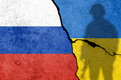 Das Bild ist eine Collage aus der russischen und der ukrainischen Flagge mit dem Schatten eines bewaffneten Soldaten