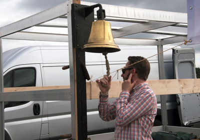 Eine mobile Glocke wird zum Gottesdienst auf dem Weserwehr geläutet
