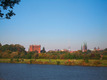 Grünflächen und Bäume am Weserufer mit dem Bremer Dom und weiteren Gebäuden am Horizont.