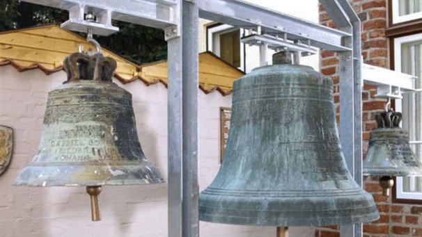 Das Bild zeigt drei historische Glocken aus dem 18. Jahrhundert im Innenhof eines Lübecker Museums