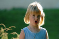 Das Foto zeigt ein singendes kleines Mädchen mit blonden Haaren und einem blauen T-Shirt