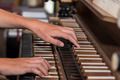 Hände spielen auf der Tastatur einer Orgel