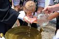 Das Bild zeigt die open air-Taufe eines kleinen Jungen.