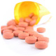 Tabletten fallen aus einem umgestoßenen Medikamentenbehälter