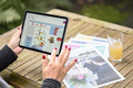 Das Foto zeigt eine Frau mit einem Tablet, auf dem die bremer kirchenzeitung online zu sehen ist. Auf dem Tisch die Papierausgabe und ein Glas Orangensaft