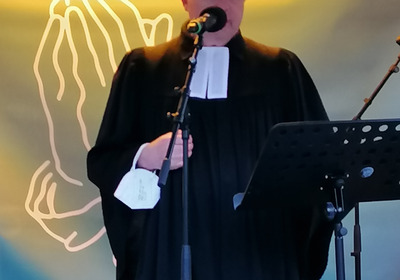 Das Foto zeigt Pastor Bernd Kuschnerus, den Schriftführer der Bremischen Evangelischen Kirche, im Talar. Er spricht auf der Demonstration auf dem Bremer Marktplatz aus Anlass des russischen Überfalls auf die Ukraine.