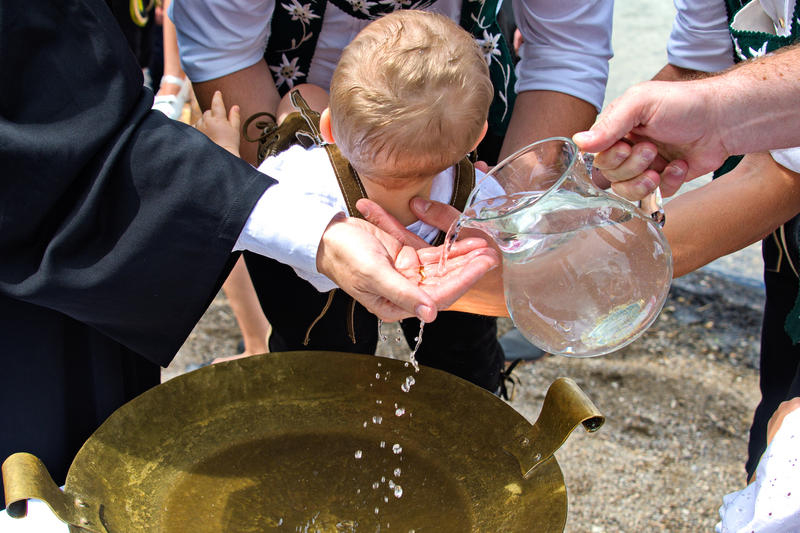 Das Bild zeigt die open air-Taufe eines kleinen Jungen.