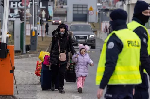 Das Foto zeigt eine geflüchtete Ukrainerin mit einem kleinen Kind an der Grenze.